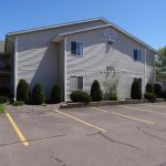 side-of-tan-apartment-building-parking-spaces