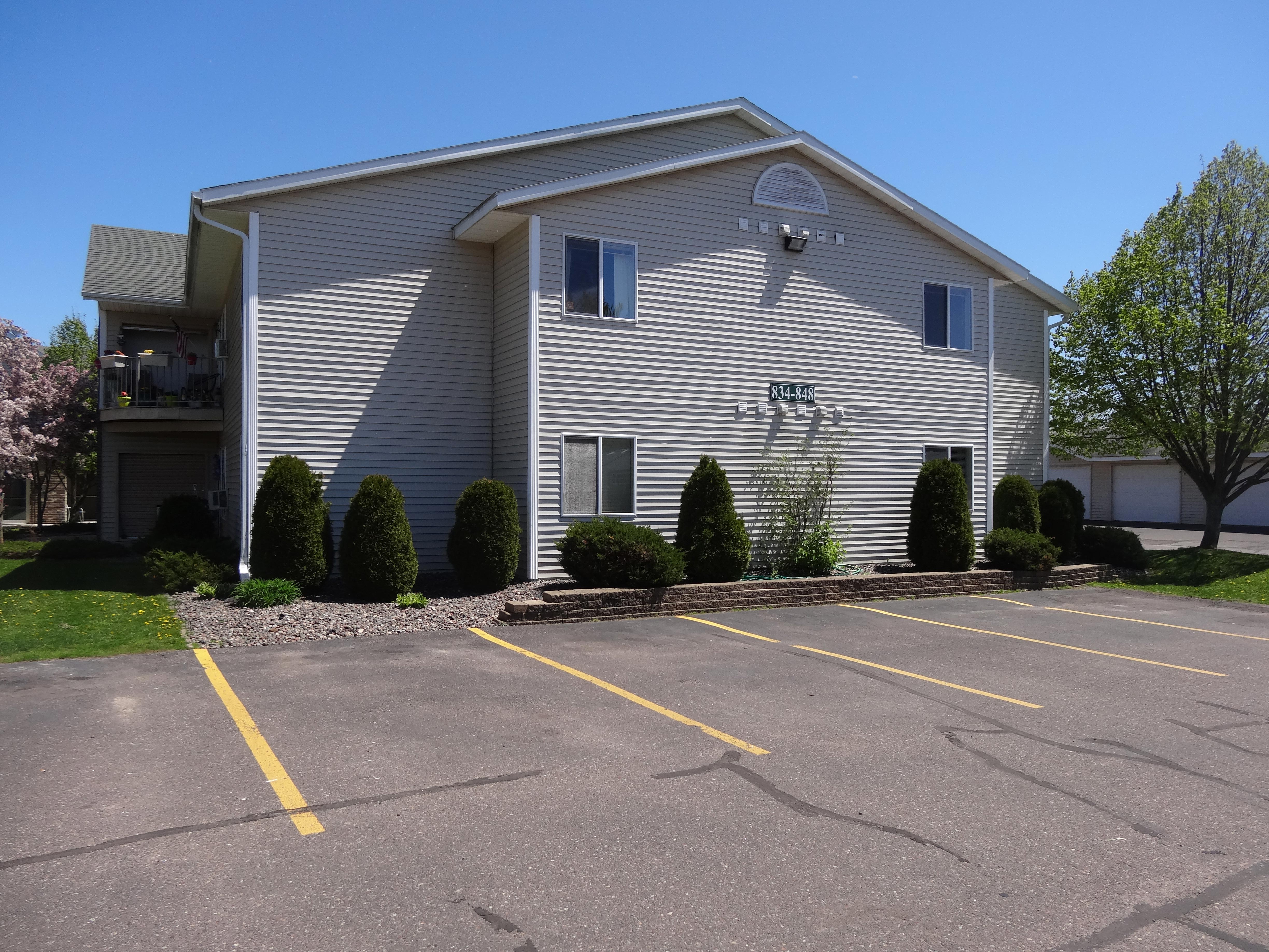 side-of-tan-apartment-building-parking-spaces