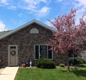 outside-of-a-condo-with-front-lawn-and-flowered-tree